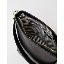 Load image into Gallery viewer, The Bobbi Bucket Bag Maxi - Classic Leather in black, with its gold zipper slightly open, unveils a gray and white striped fabric lining. This bag includes an adjustable strap with a gold-tone ring attachment and showcases an embossed brand logo on the exterior. It is crafted from ethically sourced materials, embodying style with integrity.
