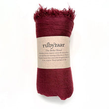 Load image into Gallery viewer, Rolled red scarf with fringe, wrapped in a brown label that reads &quot;rubyzaar The Boho Scarf.&quot; This bohemian style accessory is hand-woven from a cotton viscose blend and hand-dyed by a weaving collective in Thailand. Dimensions are 72 inches by 29 inches. Care instructions include hand washing and air drying.
