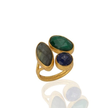 A gold ring adorned with a trio of stones: an oval emerald, an elongated oval labradorite, and a round lapis. These stones are clustered on a thick gold band with a reflective surface beneath them.