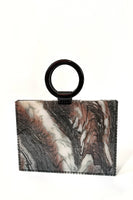 Load image into Gallery viewer, Introducing the Resin Valet Bag, a rectangular tote adorned with a marble-like pattern in shades of brown, black, and white. It showcases a large, round leather handle attached at the top. The plain white background accentuates the bag&#39;s intricate design and vinyl side panels.
