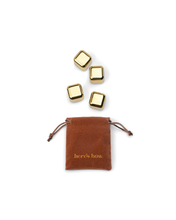 Load image into Gallery viewer, An open small brown drawstring pouch with &quot;here&#39;s how.&quot; in gold text is positioned at the bottom of the image. Above it, four Ruby Cubes Cocktail Chillers in Gold are displayed in a staggered formation, ideal for keeping drinks cold, set against a plain white background.
