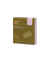 Load image into Gallery viewer, A khaki green and pink box for the &quot;Ruby Cubes Cocktail Chillers in Gold - Set of 4&quot; by &quot;here&#39;s how.&quot; The front features a minimalist gold line drawing of two freezable cubes and a drink, accompanied by a &quot;100% Stainless Steel&quot; label. Ideal for keeping drinks cold. Box dimensions: 1 x 1 inch.
