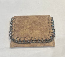 Load image into Gallery viewer, A compact, textured beige clutch featuring a metallic chain trim along its edges rests on a light surface. The Chain Wallet showcases a rustic, worn-leather appearance, while the industrial-style chain provides a striking contrast to the soft material.
