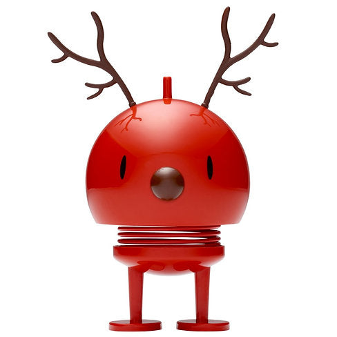 The Hoptimist Reindeer Bumble is a glossy red, round figurine with antler-like decorations on top, capturing the essence of a reindeer and embodying the festive spirit of Christmas decorations. Its simple face, small eyes, and round nose add charm, while two spring legs and flat feet provide a playful, bouncy touch to any setting.