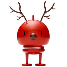 Load image into Gallery viewer, The Hoptimist Reindeer Bumble is a glossy red, round figurine with antler-like decorations on top, capturing the essence of a reindeer and embodying the festive spirit of Christmas decorations. Its simple face, small eyes, and round nose add charm, while two spring legs and flat feet provide a playful, bouncy touch to any setting.
