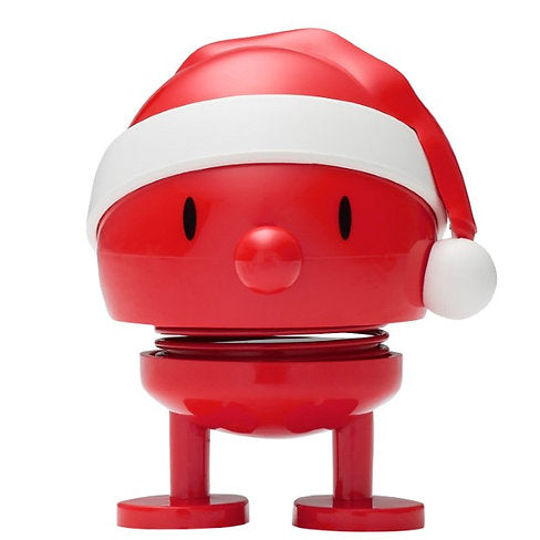 The Hoptimist Santa Bumble is an ideal gift for Advent calendars. This red, round toy figure comes with cartoon-style eyes and a small nose, standing on two short legs with visible springs that give it a playful and bouncy look. Its festive Santa hat is accented with white trim and a pom-pom, adding extra charm.