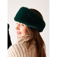 Load image into Gallery viewer, A woman with long brown hair is sporting a Cozy Cabin Headband in dark green faux fur. She is dressed in a chunky-knit beige sweater and smiles softly against a plain, light-colored background that accentuates her profile.
