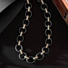 Load image into Gallery viewer, The Perfect Chunky Mixed Metal Link Necklace features large black circular links connected by small 14K gold connectors, laid out flat against a dark background. The alternating black and gold pattern creates a bold contrast, further enhanced by cubic zirconia stones that highlight the chain&#39;s elegant design.
