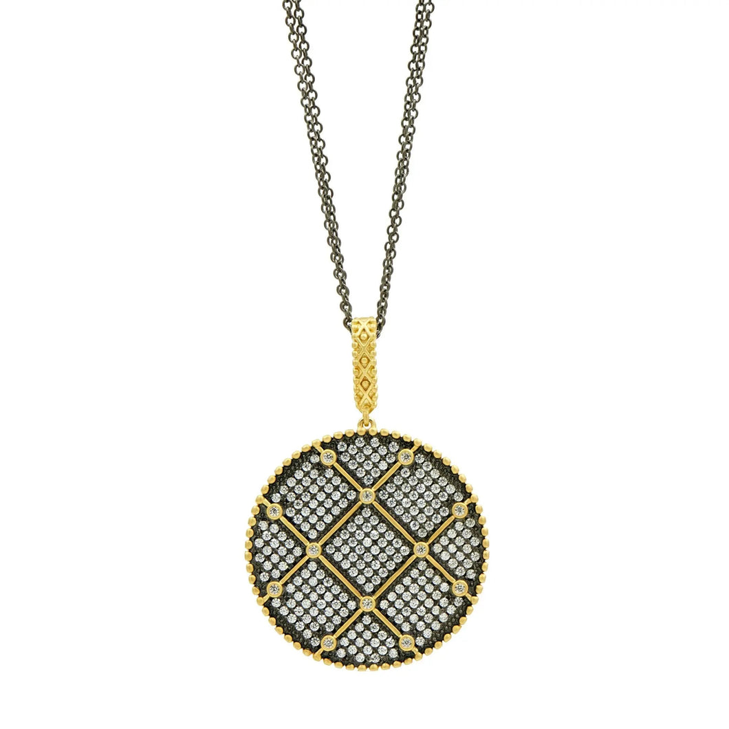 Introducing the Signature Double Sided Pendant Necklace: a circular pendant featuring a geometric lattice pattern adorned with small diamonds arranged in a grid. This exquisite piece boasts a gold border and bail, elegantly suspended from a dark black rhodium chain. The interplay of gold and silver tones adds to its sophisticated allure.