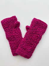 Load image into Gallery viewer, Displayed side by side on a white background, the Wool Knit Fingerless Gloves are vibrant pink and crocheted from soft sheep wool. They feature a textured floral pattern that highlights intricate craftsmanship and include thumb holes to emphasize their fingerless design. Hand washing is recommended.
