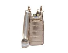 Load image into Gallery viewer, Introducing the HydroBag: a chic metallic gold crossbody featuring a quilted front pocket adorned with elegant gold hardware. It comes with an adjustable striped strap in beige and silver. A convenient top opening reveals a reusable water bottle, ideal for staying hydrated while on the move.
