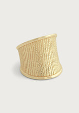 Load image into Gallery viewer, Introducing the Enchanted Forest Bark Ring, an exquisite gold ring showcasing a textured woodgrain motif that mimics tree bark. It features vertical lines and an oval knot design on a micro-hammered 18k gold band. The ring is wide at the front but elegantly tapers towards the bottom, offering a modern and unique look against a plain, light gray background.
