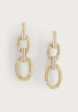 Load image into Gallery viewer, The Enchanted Forest Chain Earrings are crafted from 18k gold-dipped brass and feature two interlocking oval loops. These loops are textured and embellished with hand-set crystals, while the upper loops display three vertical rows of additional gemstones, blending intricate detailing with elegant simplicity.
