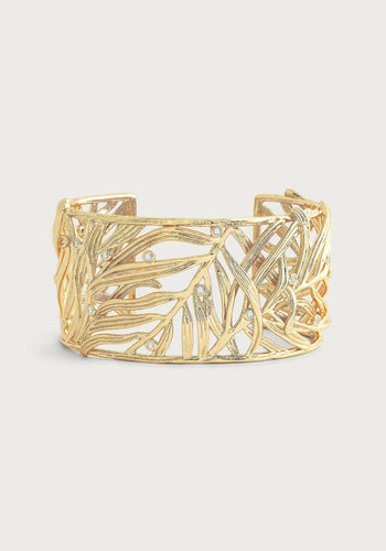 Introducing the Palm Leaves Cuff: a gold cuff bracelet featuring an openwork leaf pattern adorned with hand-set crystals. Its design intricately weaves leaves together, resulting in a delicate and elegant appearance. Crafted from 18K gold-plated brass, the shiny finish elevates its luxurious look.