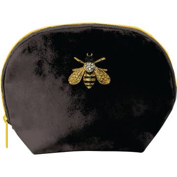 The Clamshell Bag - Velvet with Brooch Embellishment is a black velvet pouch featuring a bee design with gold wings, a black and gold striped body adorned with a silver gem, and a gold zipper. Its elegant simplicity highlights the detailed bee motif beautifully.