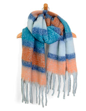 Load image into Gallery viewer, A Cozy Scarves piece hangs elegantly on a wooden hanger, showcasing its blend of soft and warm textures. It features broad, fuzzy stripes in shades of blue, orange, and light gray. The fringed edges at the bottom add to its textured charm.
