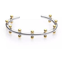 Load image into Gallery viewer, The Cindy Studded Cuff is an open silver bracelet featuring 18k gold-plated beads that are evenly spaced along its outer edge, creating a modern and elegant design. This hypoallergenic piece offers sophistication and is elegantly displayed against a plain white background.
