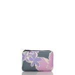 Load image into Gallery viewer, The &quot;Aloha Pouches&quot; is a small rectangular pouch, featuring large purple flowers and green leaves on a gray and pink backdrop. It has a black top zipper, making it an ideal travel companion for keeping toiletries organized against a pristine white interior.
