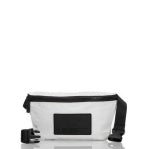 The Aloha Hip Pack is a stylish white rectangular waist bag perfect for travel. It has an adjustable black strap, a sleek zippered closure, and a front black patch on a plain white background. Embrace your journeys with this chic hip pack companion.