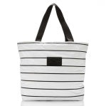 The Aloha Day Tripper Tote is a white tote with black stripes, featuring two black handles and a small rectangular front patch. Its simple, minimalistic design is perfect for casual use, with a plain white background highlighting the pattern.