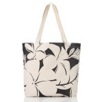 The Aloha Reversible Tote is a canvas bag with beige handles and a striking black and white floral design. Large flowers with overlapping petals create an eye-catching pattern, beautifully showcased on a plain white background.