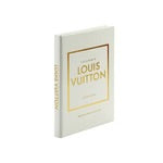 The "Little Book of Louis Vuitton" encapsulates the essence of luxury fashion with its petite, rectangular design featuring a white cover adorned with "Louis Vuitton" and "Catwalk" in gold lettering. The title, along with "The Complete Fashion Collections," graces the cover, echoing the signature style of their renowned monogrammed bags. The spine also showcases "Louis Vuitton" and "Catwalk" in a matching gold font for an elegant touch.