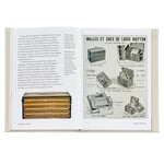 A copy of the *Little Book of Louis Vuitton* is open on a white surface, revealing vintage advertisements on the right page. These ads feature luxurious Louis Vuitton suitcases and monogrammed bags, illustrated with monochrome images showcasing various luggage styles accompanied by French text. The left page contains a paragraph of text without any images.