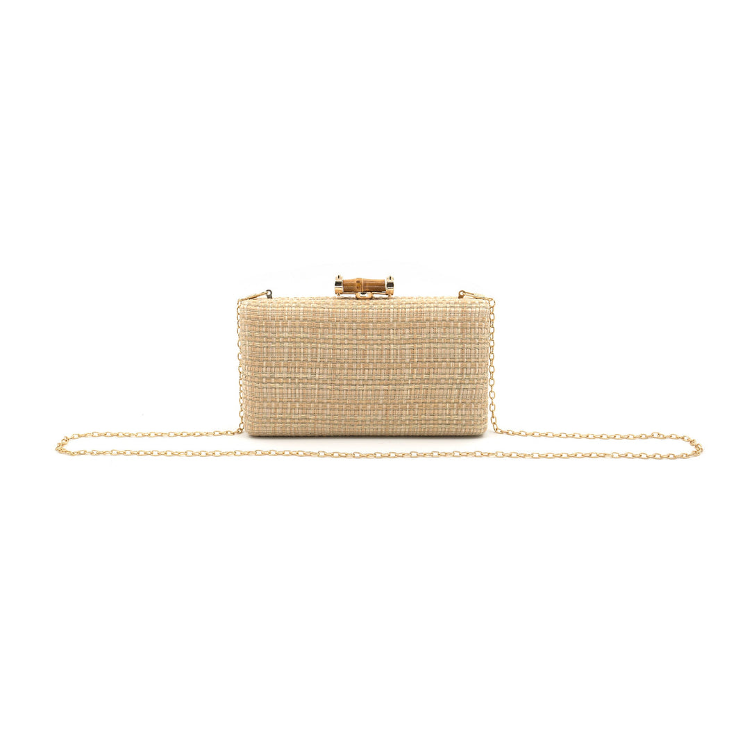 The Straw Clutch, a rectangular beige bag with a textured straw surface and gold clasp, is centered on a white background. It features a long gold chain strap on both sides and measures 8 inches, giving it an elegant touch.