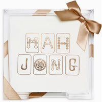 Load image into Gallery viewer, A clear acrylic tray elegantly encases a white box adorned with decorative gold letters reading &quot;MAH JONGG,&quot; wrapped in a shiny gold ribbon tied into a bow. The Cocktail Napkin Acrylic Tray Set is perfect as a hostess gift for year-round entertaining.
