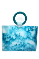 Load image into Gallery viewer, The Resin Valet Bag is a tote with a marbled blue and white pattern and a large round teal leather handle at the top. It features stitched edges, resembling swirling water or clouds, with the handle attached via a small teal loop and reinforced by a sturdy vinyl bottom.
