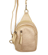 Load image into Gallery viewer, The Skyler Sling Bag is a compact, small beige backpack made of pebbled vegan leather. It has two main zip compartments, a front zip pocket, adjustable convertible strap, and gold-tone hardware like zipper pulls and ring attachments.
