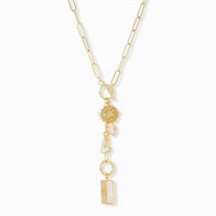 Load image into Gallery viewer, The Lariat Toggle Charm Necklace features a gold paperclip chain with charms such as a sunburst, faceted clear crystal, and hexagonal and rectangular white stones, beautifully arranged vertically against a plain white background.
