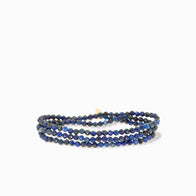 Load image into Gallery viewer, A semi-precious stone stretch bracelet features multi-colored, three-strand, polished blue beads with subtle hue variations for a rich texture. Intertwined strands complement the distinct accent of a clasp amidst the deep blue tones.
