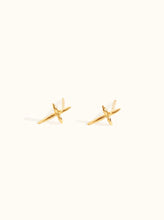 Load image into Gallery viewer, On a light background are two small, gold Droplet Cross Studs, each featuring an elegant polished finish with symmetrical lines creating an &quot;X&quot; shape. Handcrafted in Nashville, these vermeil studs offer a minimalistic design that is ideal for an elegant earring stack suitable for everyday wear.
