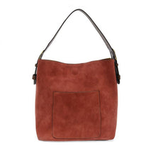 Load image into Gallery viewer, The Hobo 2 in 1 Faux Suede Handbag features a rust-colored design with a single dark brown shoulder strap and a large square pocket on the front. Its simple, sleek aesthetic is enhanced by a round button detail above the pocket, providing versatile style for any occasion.
