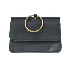 Load image into Gallery viewer, The Aria Ring Bag - Fall/Winter is a dark green leather clutch purse featuring a prominent gold ring on the front flap. This sophisticated bracelet bag offers a sleek texture and minimalist design, highlighted by its metallic ring handle. Made from vegan leather, it looks stunning against a white background.
