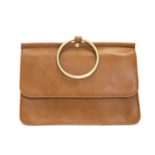 Load image into Gallery viewer, Introducing the Aria Ring Bag - Fall/Winter, a sleek tan vegan leather clutch boasting a large circular gold handle at the top. The bag presents a smooth texture and rectangular shape, complete with a flap closure. The centrally positioned gold handle on the flap adds a modern touch to this effortlessly chic bracelet bag design.
