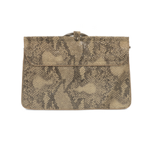 Load image into Gallery viewer, The Aria Ring Bag - Fall/Winter is a rectangular clutch purse featuring a sophisticated tan and brown snakeskin pattern, made from vegan leather. It has a small flap at the center, secured with a metal clasp for added elegance. Its textured surface mimics reptile scales, lending an exotic and refined appearance complemented by neatly stitched edges.
