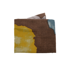 Load image into Gallery viewer, A Midweight Patterned Scarf featuring an abstract design with sections of brown, yellow, white, and blue. The pattern resembles cheetah-like shapes with soft, blended edges. The scarf is neatly folded to highlight its textured fabric and vibrant colors.
