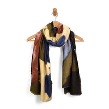 Load image into Gallery viewer, A Midweight Patterned Scarf, adorned with abstract floral designs in dark blue, olive green, beige, and maroon, elegantly drapes from a wooden hanger featuring a simple beige hook. With its soft fringed edges, the scarf exudes a cozy yet stylish charm. The plain white background accentuates the scarf&#39;s vibrant colors and rich texture.
