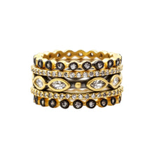 Load image into Gallery viewer, The Signature Marquise Station Ring Stack exudes captivating elegance with its set of four intricately designed gold rings. Two rings are adorned with round black stones, one showcases a marquise pattern enriched by clear stones and small diamonds, while the last features evenly spaced diamonds. These stackable rings vary in thickness and pattern, creating an ornate appearance.
