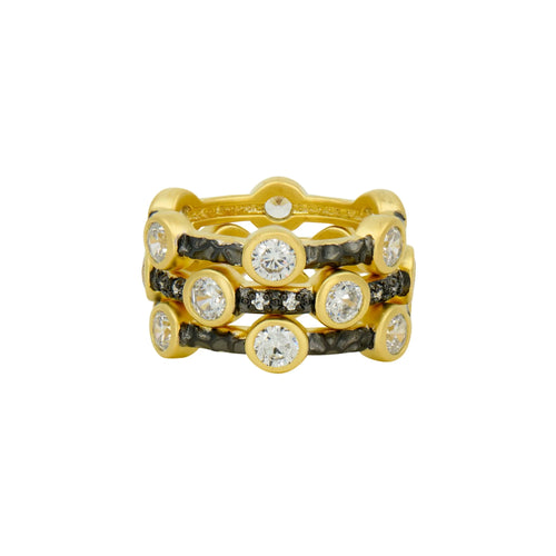 The Starry Night Ring Set is a trio of gold rings embellished with round, clear gemstones encased in bezels, complemented by bands of round, black gemstones that add contrast. The front view accentuates their detailed design and alternating arrangement of gemstones.