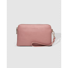 Load image into Gallery viewer, The Poppy Wristlet, made from blush pink textured vegan leather, includes a detachable wristlet and a zipper closure. The top center subtly displays embossed branding, and metallic hardware enhances its sophisticated design against a plain gray background.
