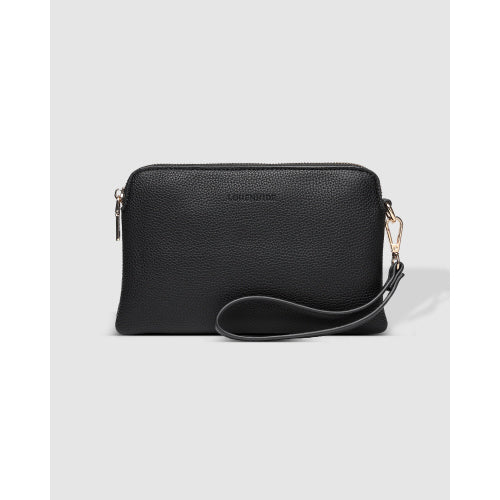 The Poppy Wristlet is a stylish black pouch made from pebble-textured vegan leather. It includes a gold top zipper and a detachable wrist strap attached with a gold clasp. The front features subtle embossed branding against a plain light gray background.