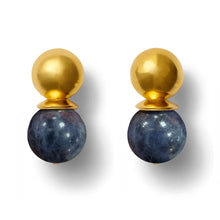 Load image into Gallery viewer, The Gold Lady Earrings are arranged side by side, each showcasing a smooth, gold domed top with a larger, polished Lapis Lazuli gemstone hanging below. Their reflective surfaces create soft shadows against the white background.
