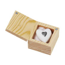 Load image into Gallery viewer, A Porcelain Gift in Wood Box with a sliding lid and magnetic closure opens to reveal a white heart-shaped soap, adorned with a smaller black heart in the center. The box showcases a natural wood grain pattern, while the soap rests elegantly on a pink cloth lining within.
