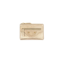 Load image into Gallery viewer, A compact gold leather wallet with a top zipper, featuring a front zippered pocket, decorative stitching, and round gold studs. The minimalist design showcases a metallic sheen against a plain white backdrop.
