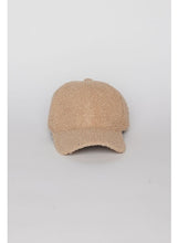 Load image into Gallery viewer, The Sherpa Cap, made of beige fleece fabric with a textured sherpa design, is showcased against a white background. This baseball hat features a curved brim and a button on top, emphasizing its soft and warm appeal perfect for fall and winter fashion.
