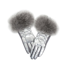 Load image into Gallery viewer, The Metallic Puffer Glove with Fox Trim, featuring intricate stitching and a luxurious winter-ready design, is showcased against a white background. These shiny silver quilted gloves are adorned with plush gray fox fur trim.
