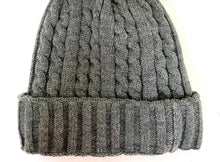 Load image into Gallery viewer, The Cable Knit Beanie with Fleece Lining is a gray hat designed with a wide ribbed cuff and a soft, thick texture, making it perfect for cold weather. The detailed stitching stands out as the beanie rests flat on a white background, and the fleece lining provides additional warmth and comfort.
